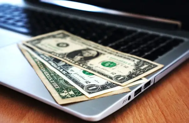 picture of dollar bills placed on a laptop
